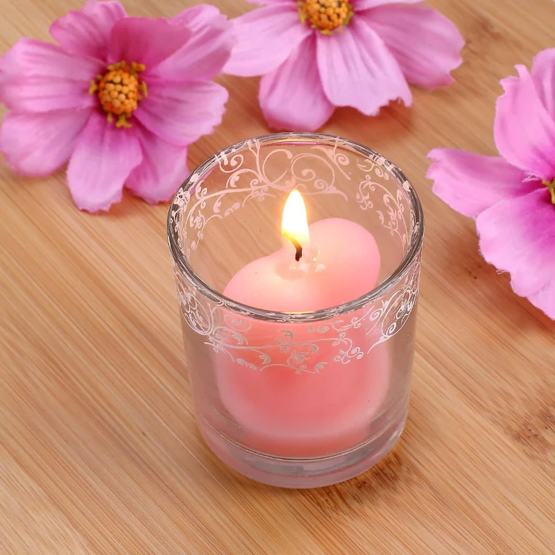 Bezaubernde Herzförmige rosa Kerze im Glas